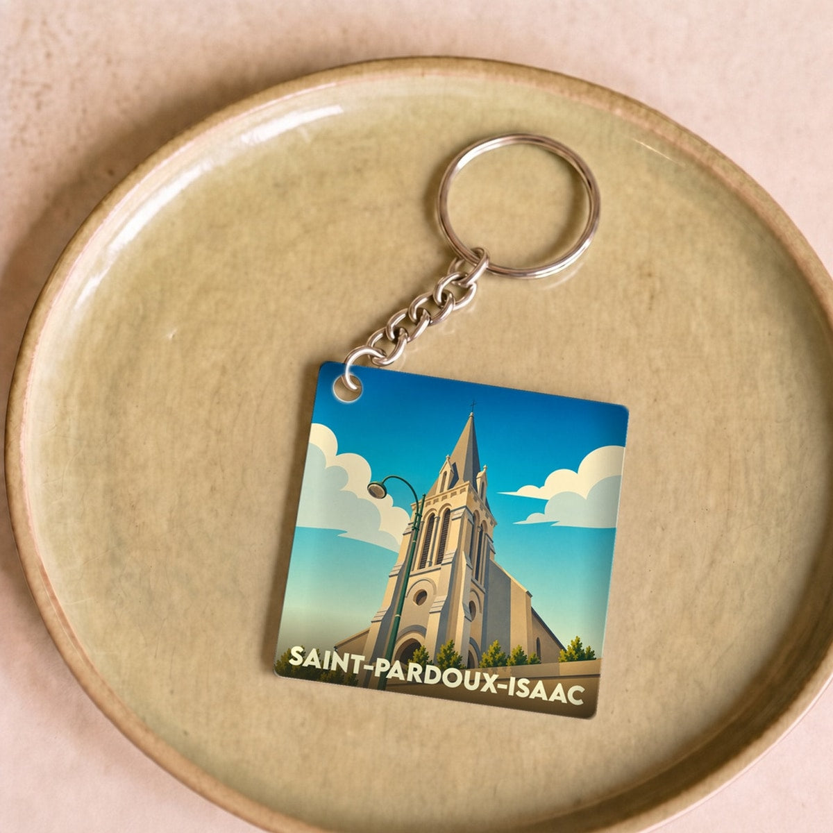 Porte-clés souvenir de la ville de Saint-Pardoux-Isaac avec une illustration stylisée de son église.