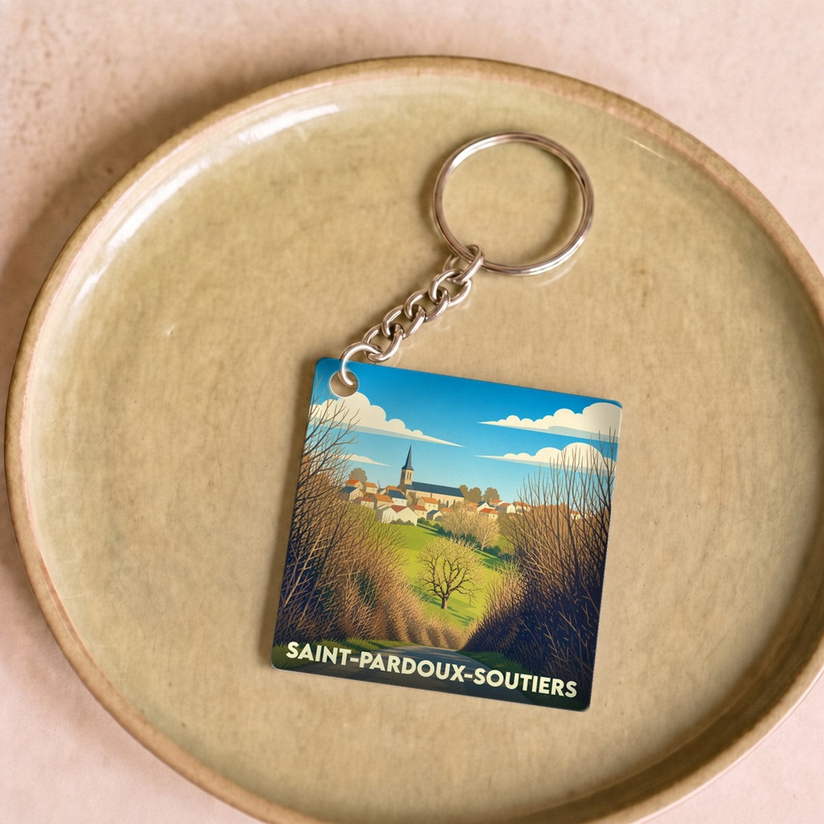 Porte-clés souvenir de la ville de Saint-Pardoux-Soutiers avec une illustration stylisée de son paysage.