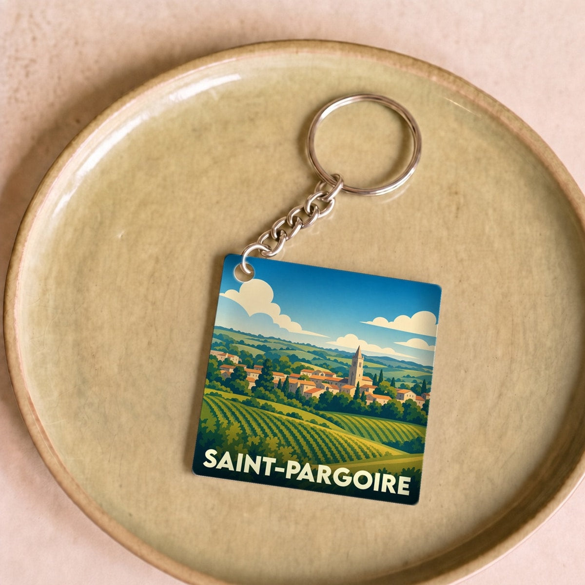 Porte-clés souvenir de la ville de Saint-Pargoire avec une illustration stylisée de vignes et du village.