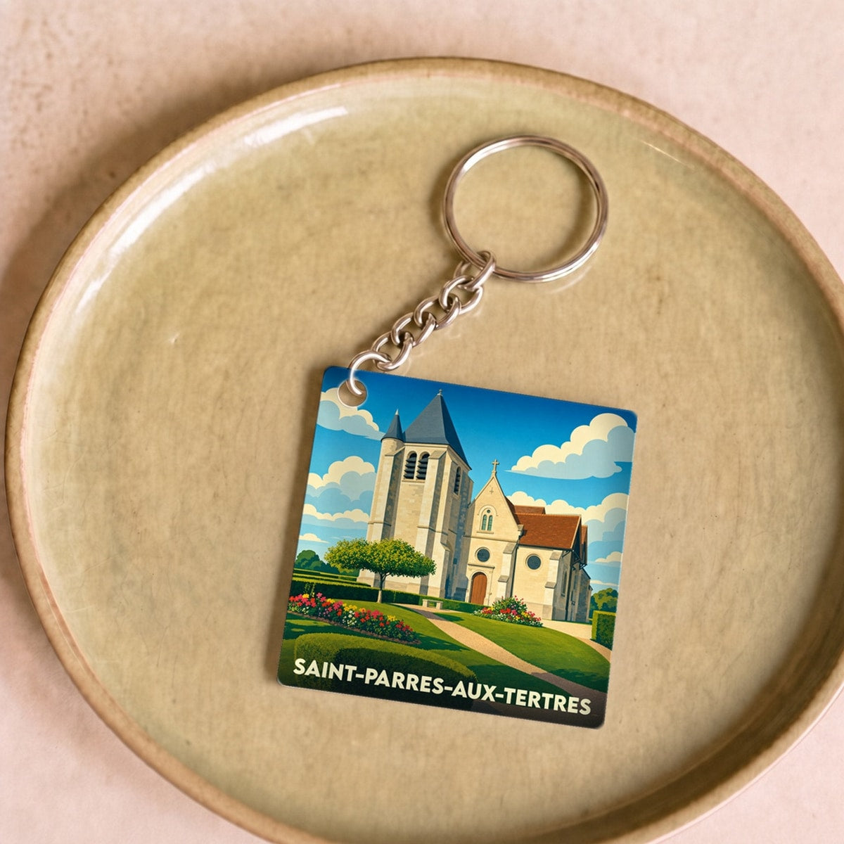 Porte-clés souvenir de la ville de Saint-Parres-aux-Tertres avec une illustration stylisée de son église.