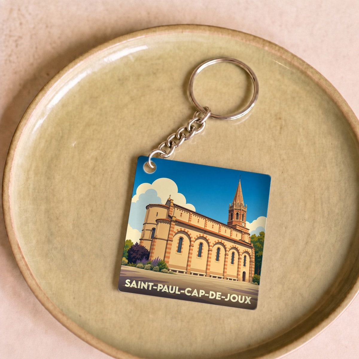 Porte-clés souvenir de la ville de Saint-Paul-Cap-de-Joux avec une illustration stylisée de son église.