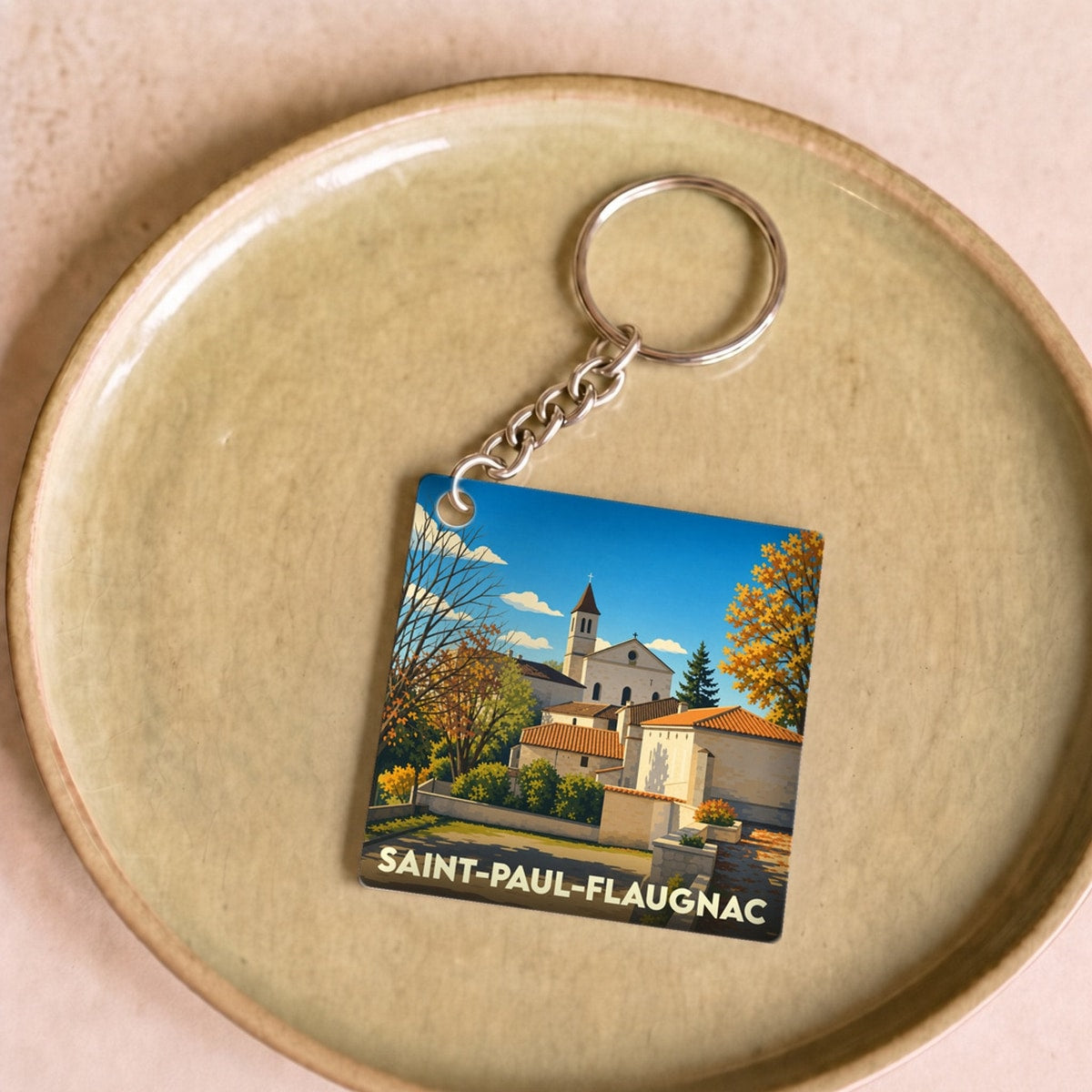 Porte-clés souvenir de la ville de Saint-Paul-Flaugnac avec une illustration stylisée.