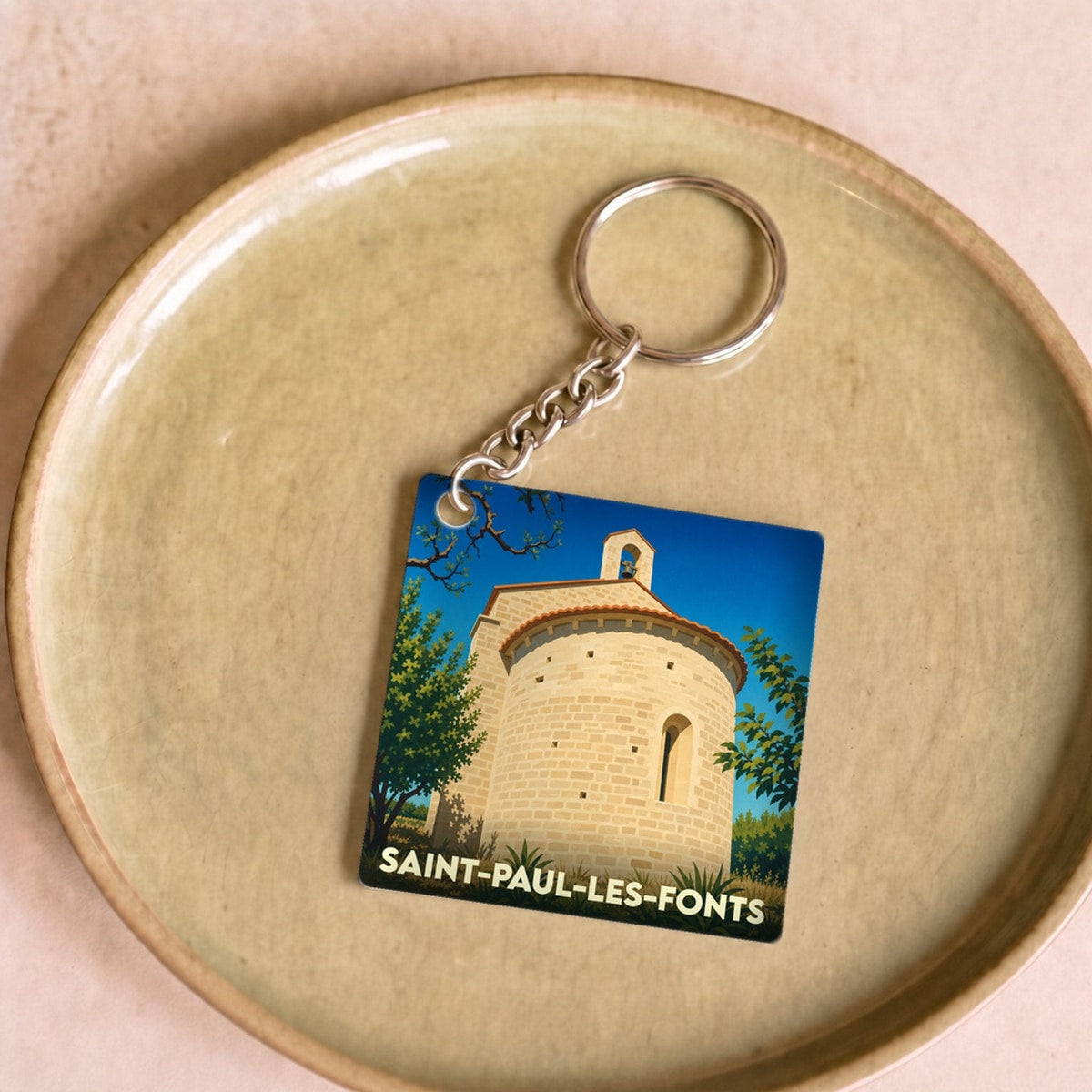 Porte-clés souvenir de la ville de Saint-Paul-les-Fonts avec une illustration stylisée.