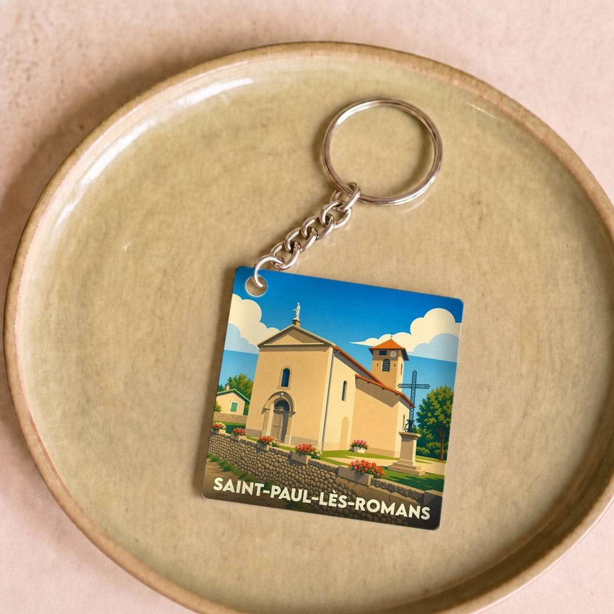 Porte-clés souvenir de la ville de Saint-Paul-lès-Romans avec une illustration stylisée de son église.