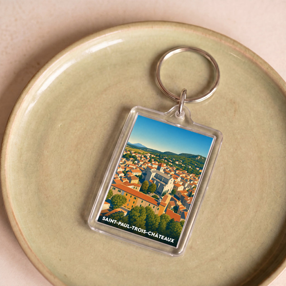 Porte-clés souvenir de la ville de Saint-Paul-Trois-Châteaux avec une illustration stylisée.