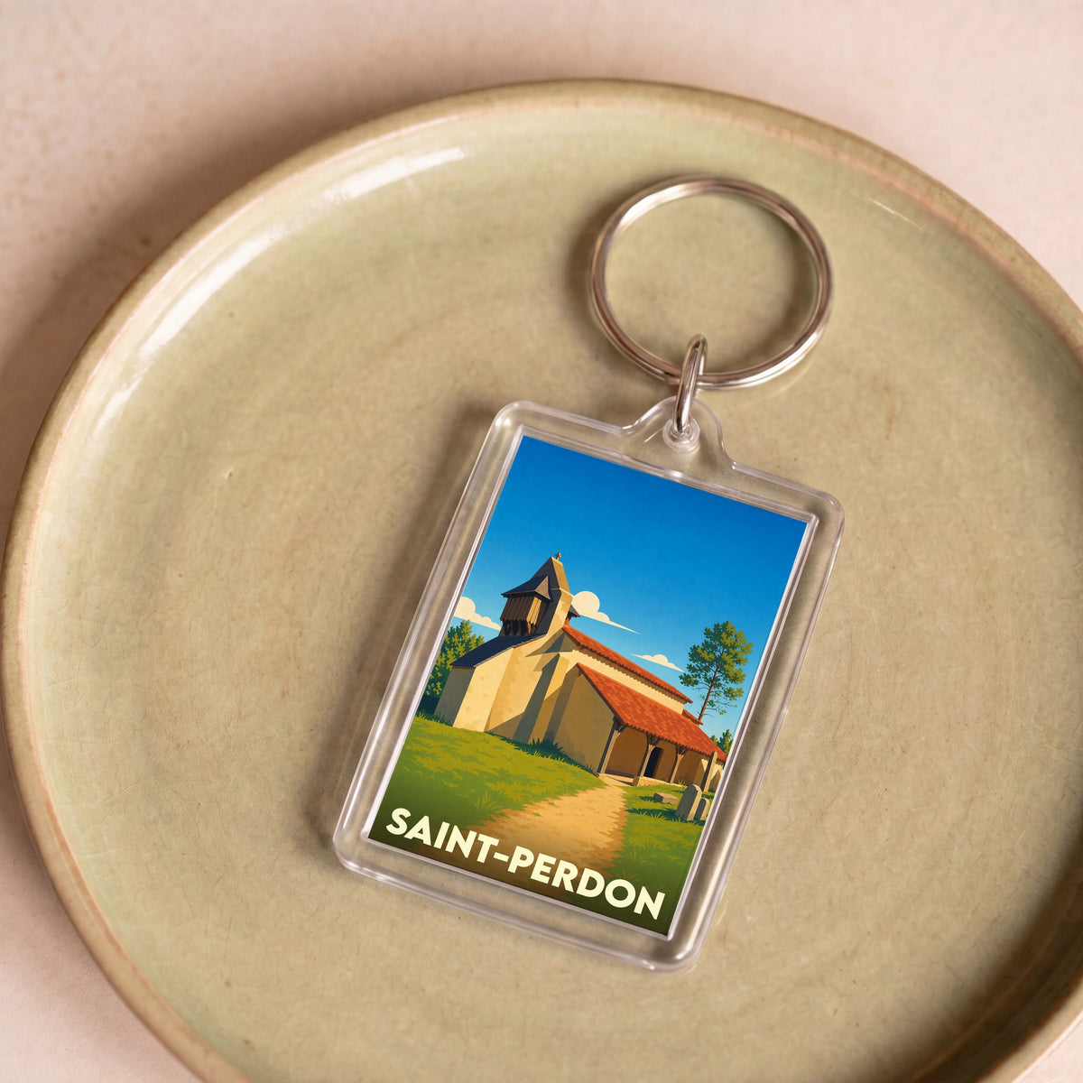 Porte-clés souvenir de la ville de Saint-Perdon avec une illustration stylisée de son église.