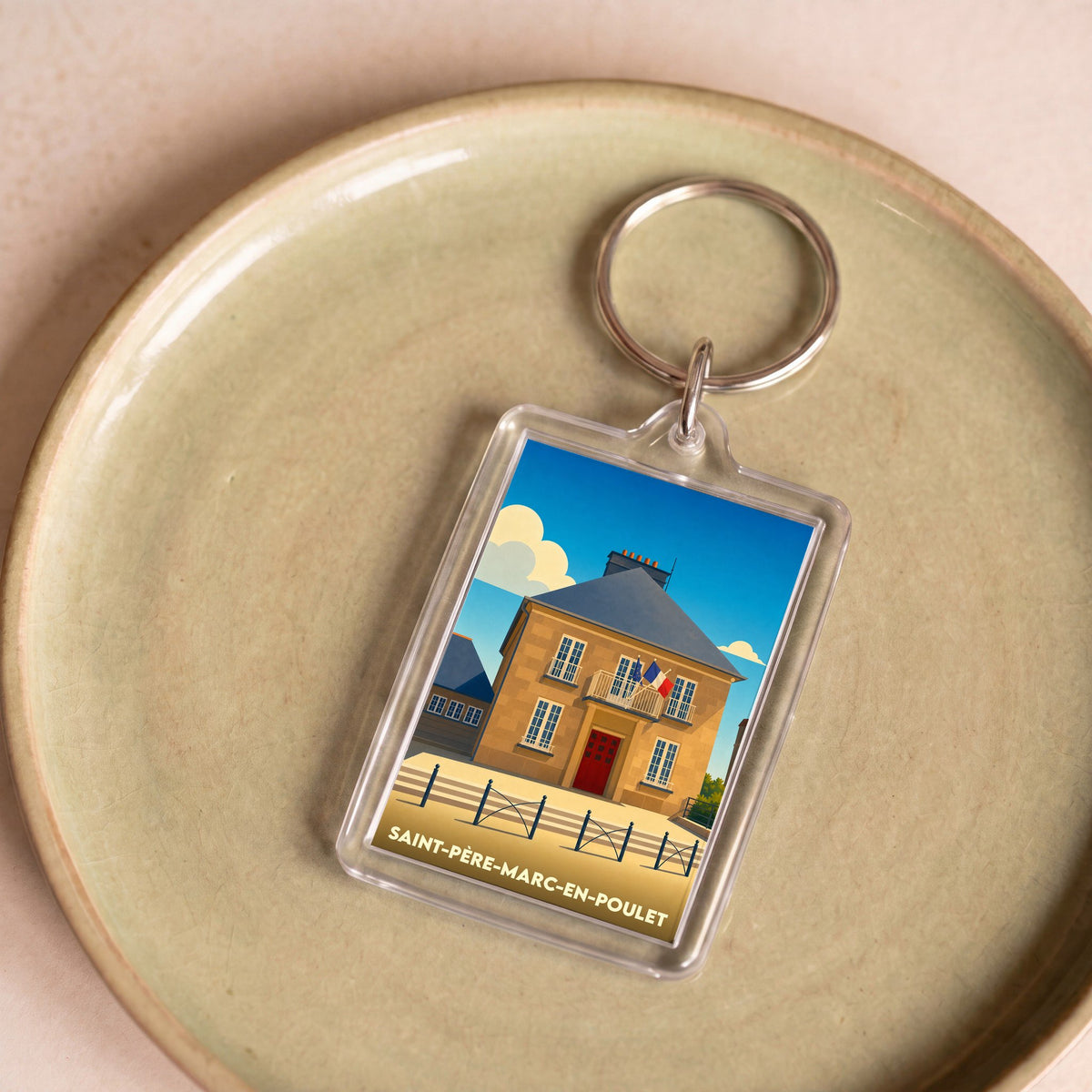 Porte-clés souvenir de la ville de Saint-Père-Marc-en-Poulet avec une illustration stylisée de sa mairie.