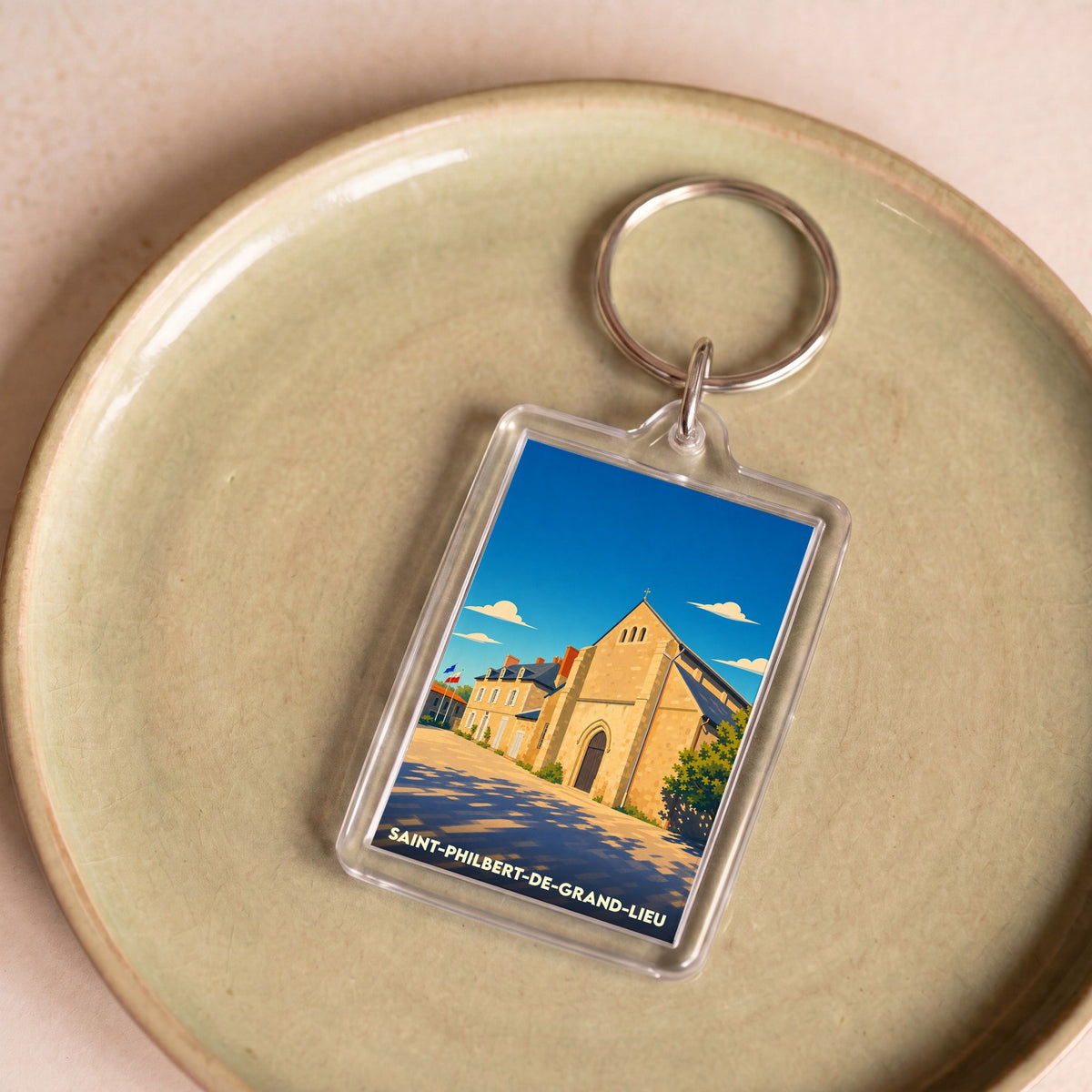 Porte-clés souvenir de la ville de Saint-Philbert-de-Grand-Lieu avec une illustration stylisée.