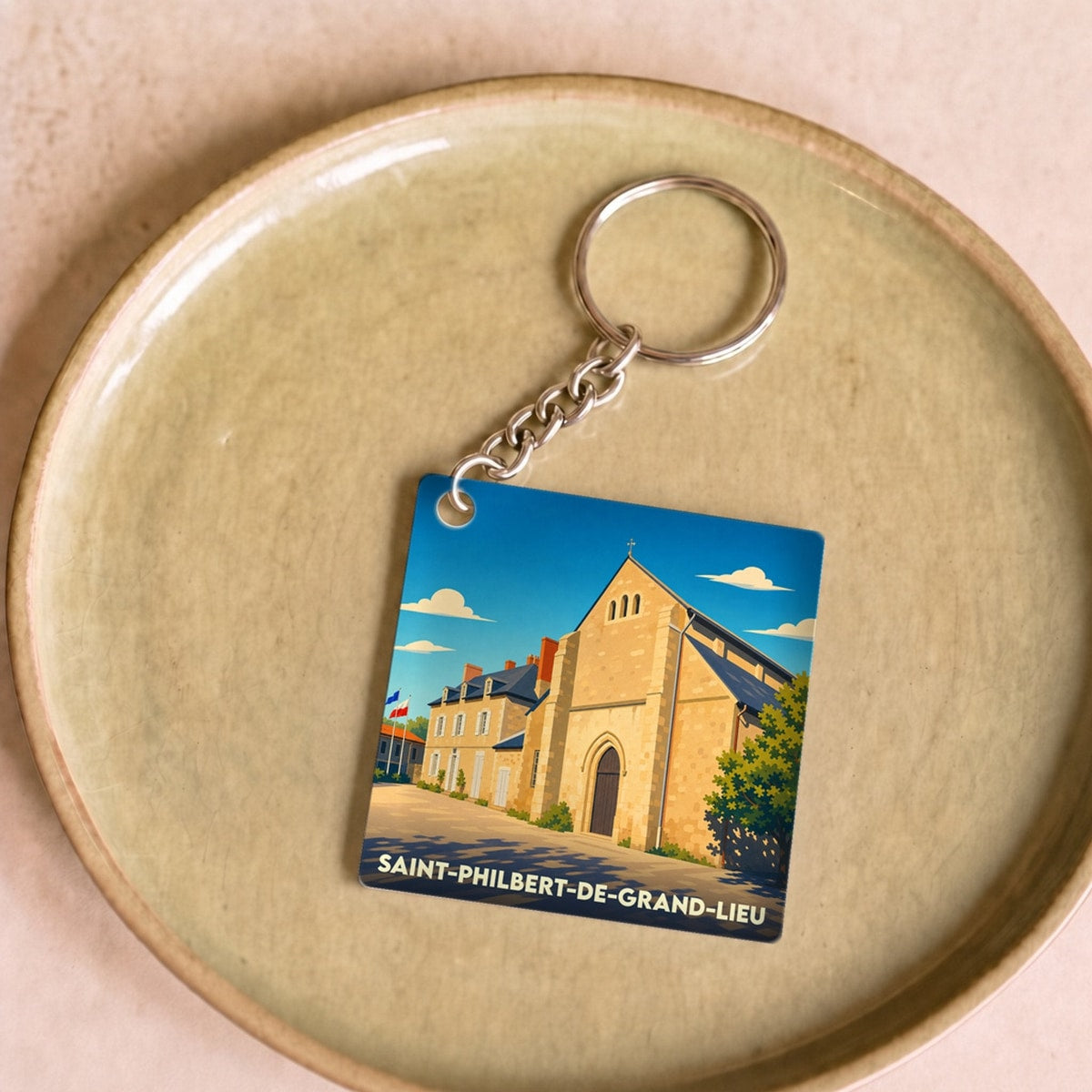 Porte-clés souvenir de la ville de Saint-Philbert-de-Grand-Lieu avec une illustration stylisée.