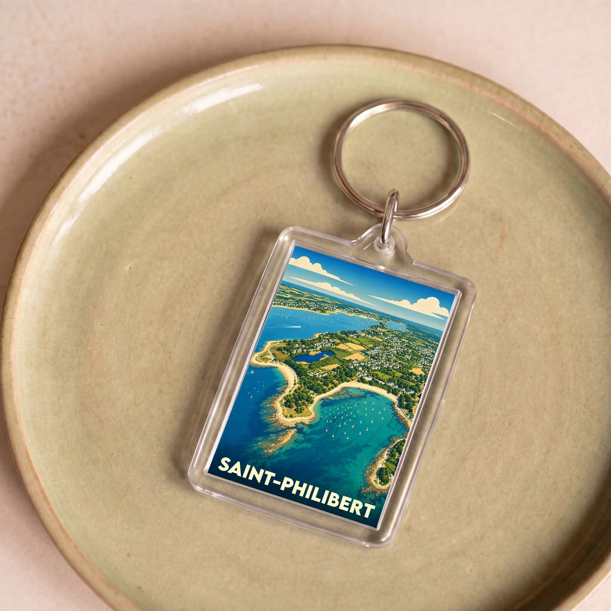 Porte-clés souvenir de la ville de Saint-Philibert avec une illustration stylisée d'un paysage côtier vu du ciel.
