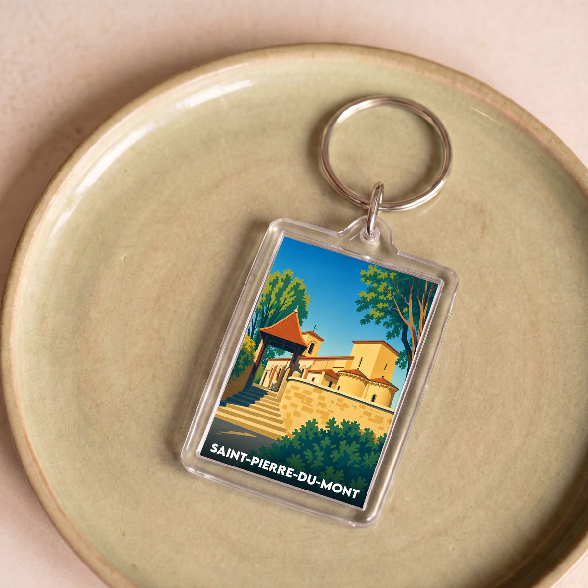 Porte-clés souvenir de la ville de Saint-Pierre-du-Mont avec une illustration stylisée.