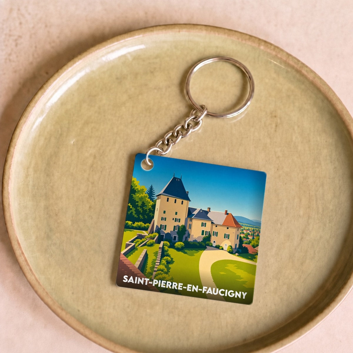 Porte-clés souvenir de la ville de Saint-Pierre-en-Faucigny avec une illustration stylisée d'un château.