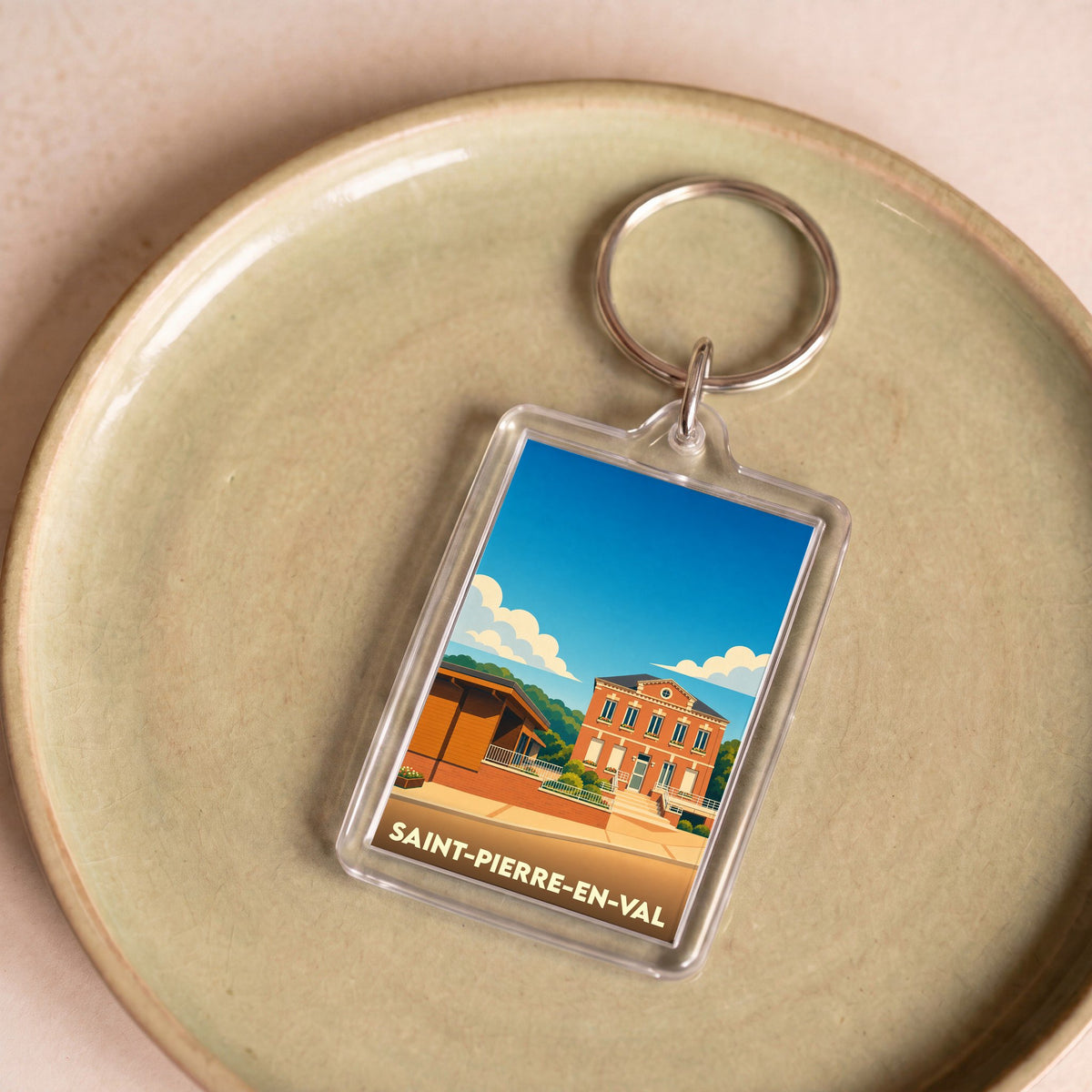 Porte-clés souvenir de la ville de Saint-Pierre-en-Val avec une illustration stylisée.