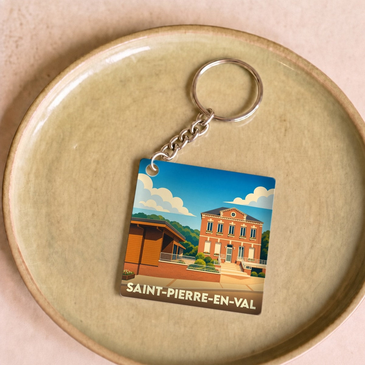 Porte-clés souvenir de la ville de Saint-Pierre-en-Val avec une illustration stylisée.