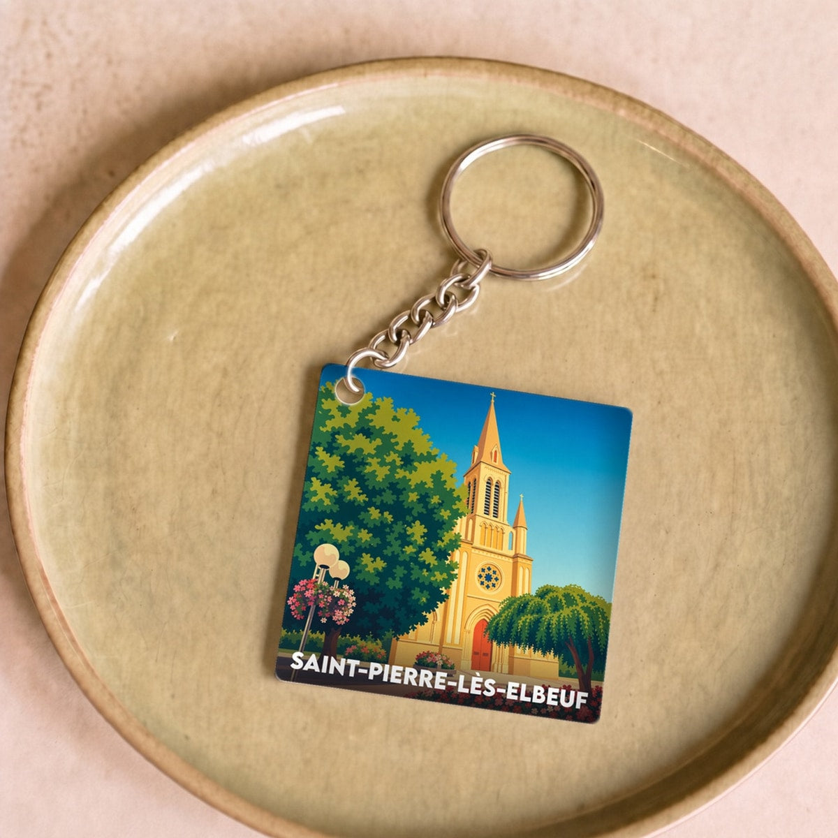 Porte-clés souvenir de la ville de Saint-Pierre-lès-Elbeuf avec une illustration stylisée de son église.
