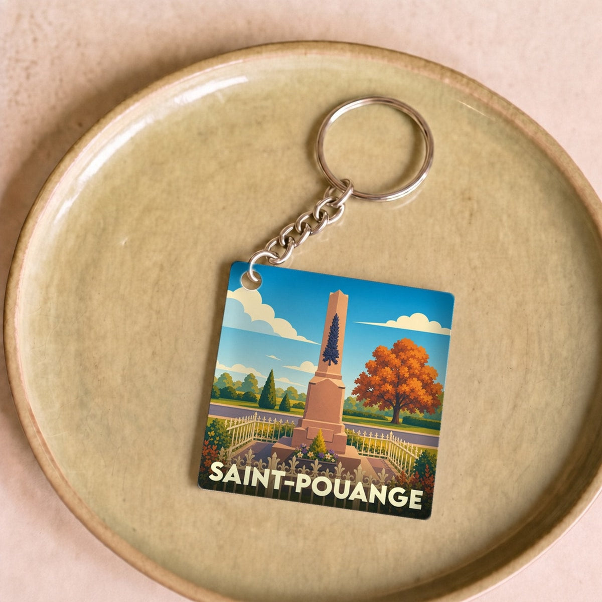 Porte-clés souvenir de la ville de Saint-Pouange avec une illustration stylisée de son monument aux morts.