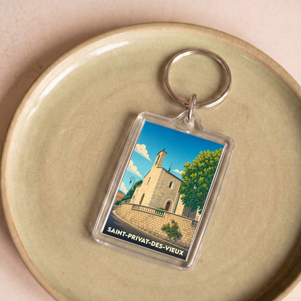 Porte-clés souvenir de la ville de Saint-Privat-des-Vieux avec une illustration stylisée de son église.