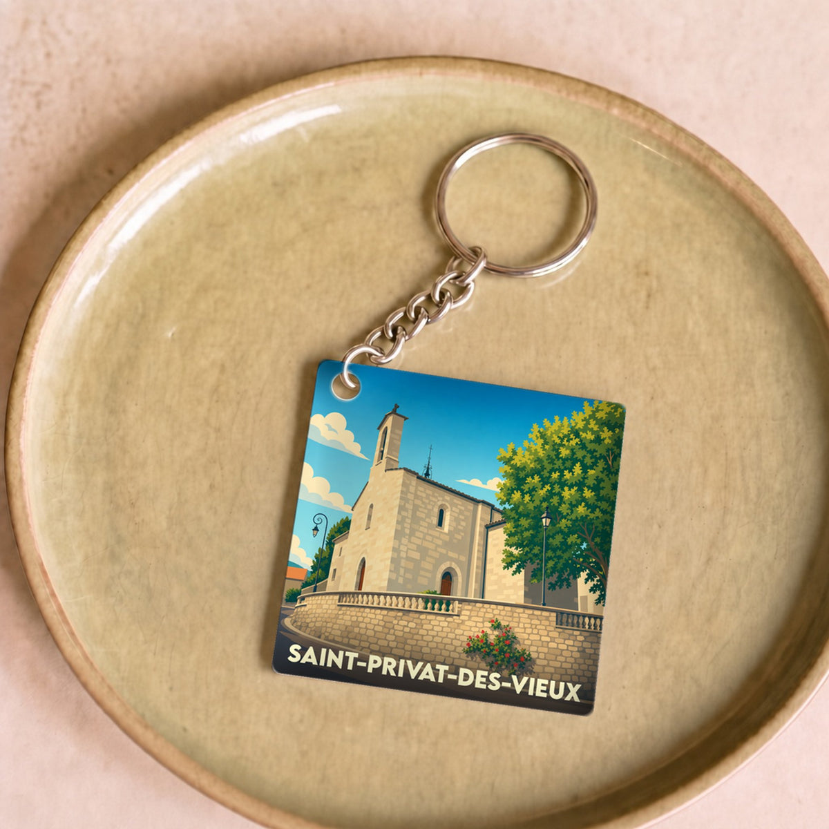 Porte-clés souvenir de la ville de Saint-Privat-des-Vieux avec une illustration stylisée de son église.