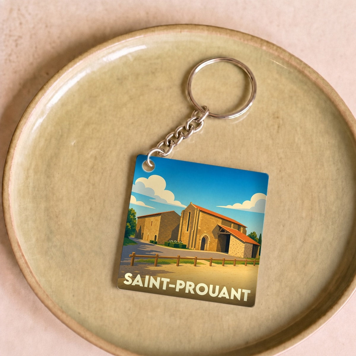Porte-clés souvenir de la ville de Saint-Prouant avec une illustration stylisée d'un monument historique.