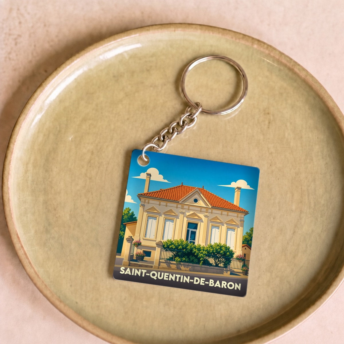Porte-clés souvenir de la ville de Saint-Quentin-de-Baron avec une illustration stylisée.