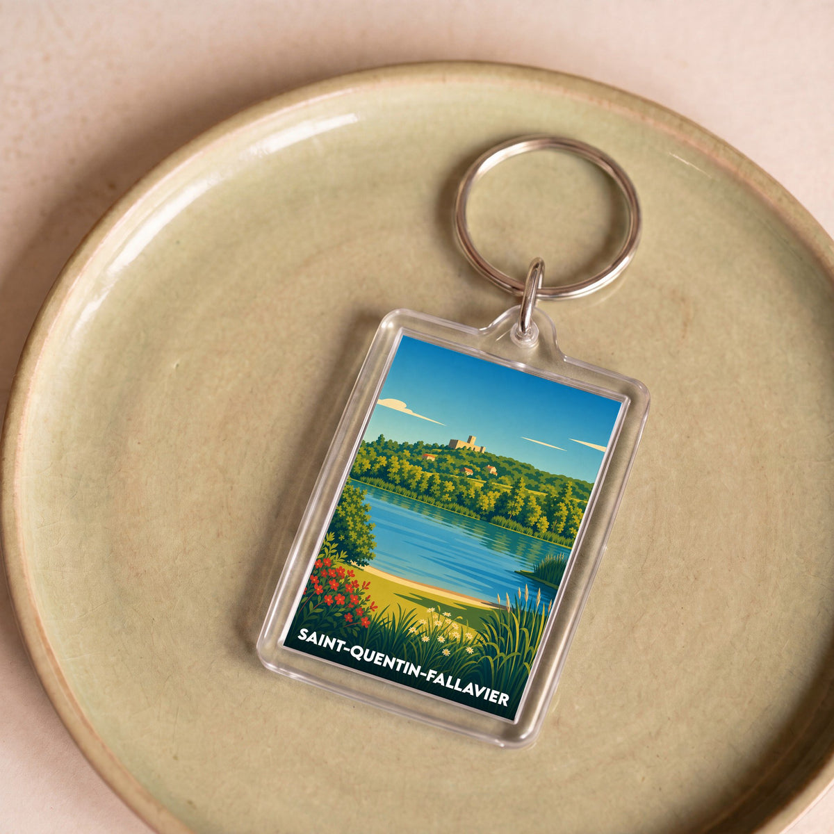 Porte-clés souvenir de la ville de Saint-Quentin-Fallavier avec une illustration stylisée d'un paysage lacustre.