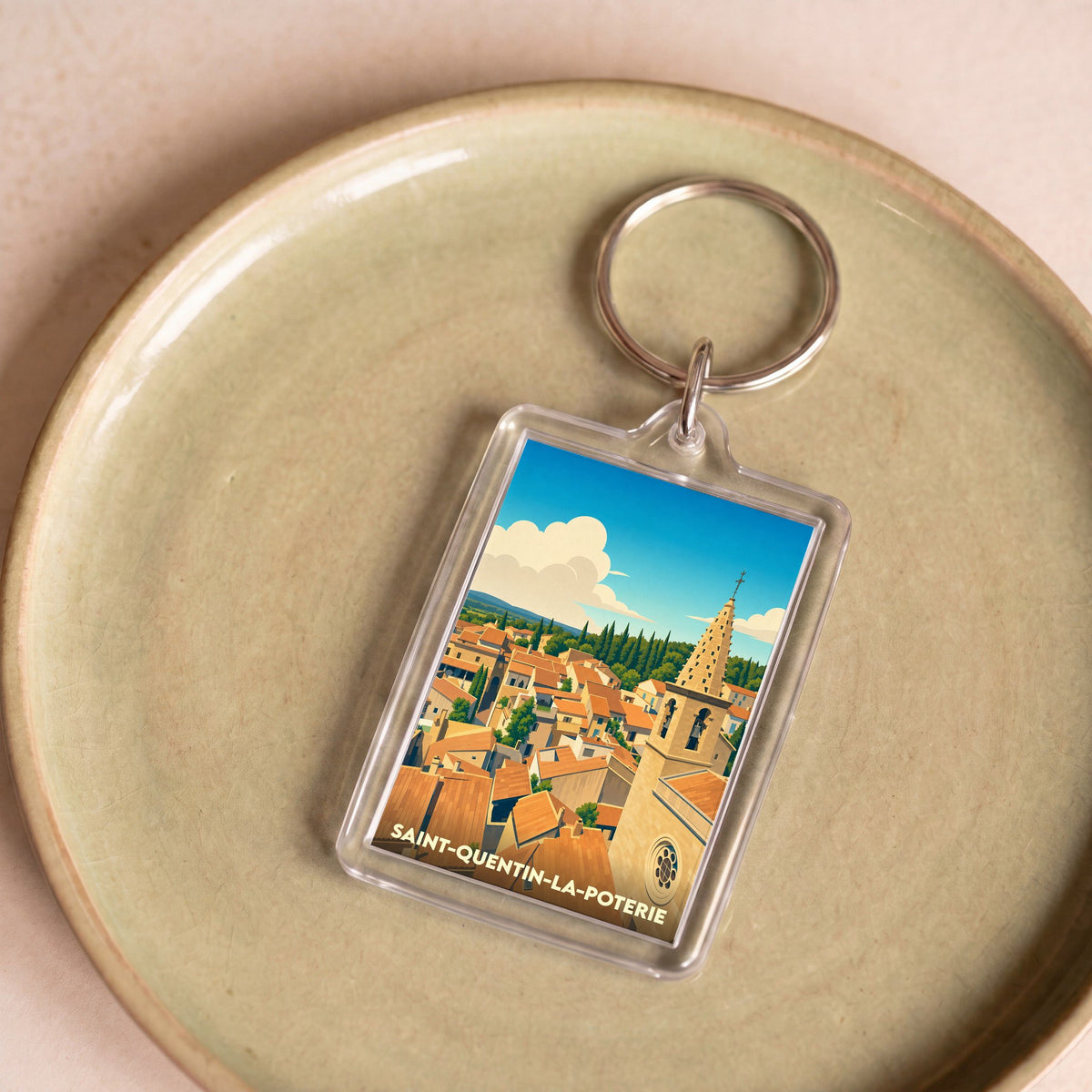 Porte-clés souvenir de la ville de Saint-Quentin-la-Poterie avec une illustration stylisée.
