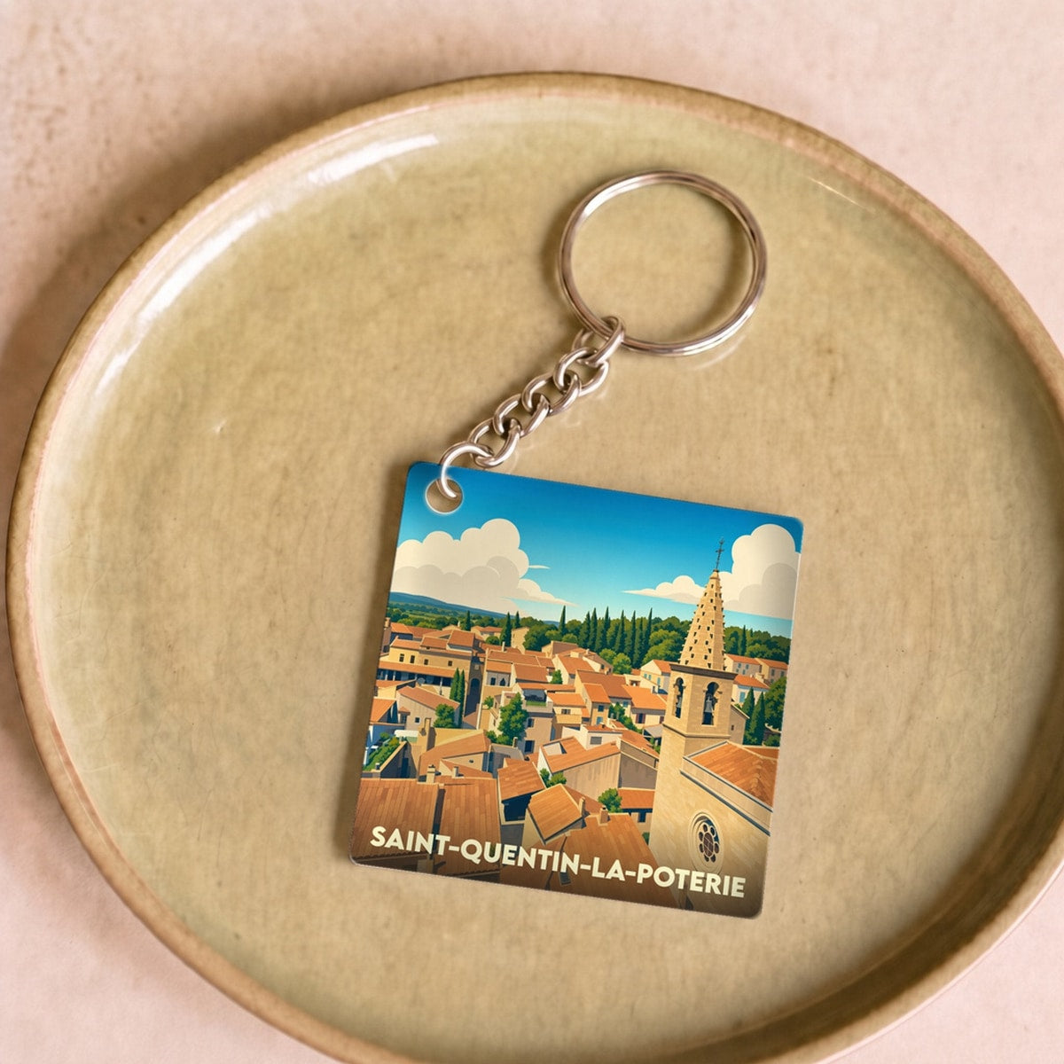 Porte-clés souvenir de la ville de Saint-Quentin-la-Poterie avec une illustration stylisée.
