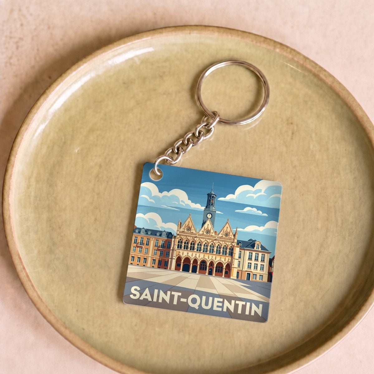 Porte-clés souvenir de la ville de Saint-Quentin avec une illustration stylisée.