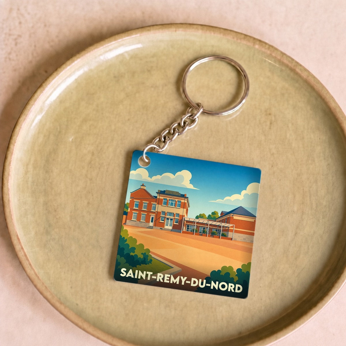 Porte-clés souvenir de la ville de Saint-Remy-du-Nord avec une illustration stylisée.