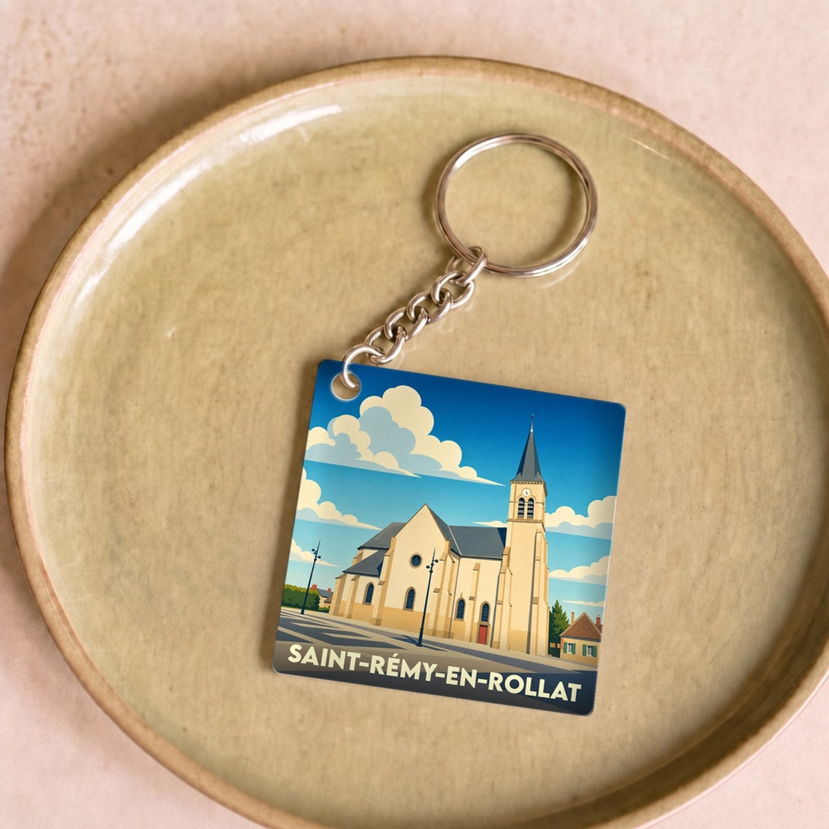 Porte-clés souvenir de la ville de Saint-Rémy-en-Rollat avec une illustration stylisée de son église.