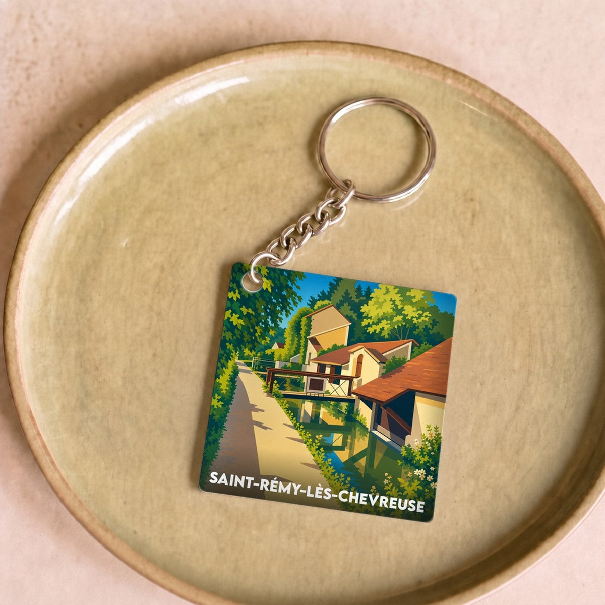 Porte-clés souvenir de la ville de Saint-Rémy-lès-Chevreuse avec une illustration stylisée.