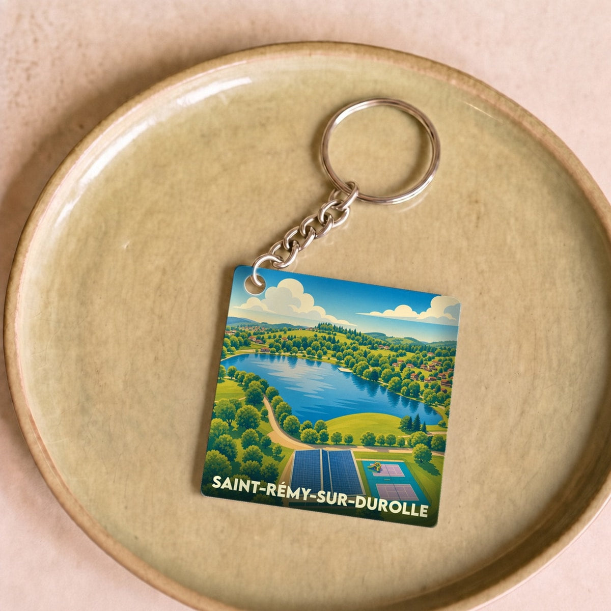 Porte-clés souvenir de la ville de Saint-Rémy-sur-Durolle avec une illustration stylisée.