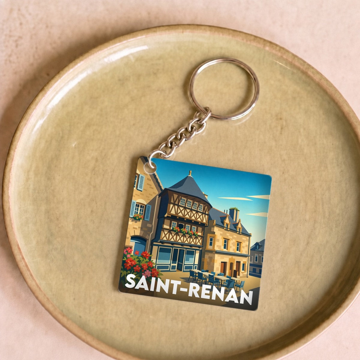 Porte-clés souvenir de la ville de Saint-Renan avec une illustration colorée et stylisée.