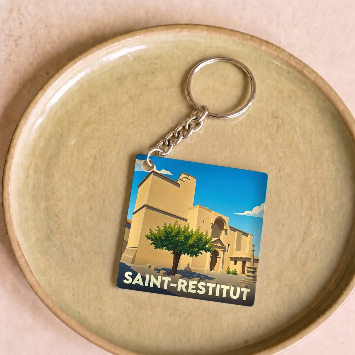 Porte-clés souvenir de la ville de Saint-Restitut avec une illustration stylisée.