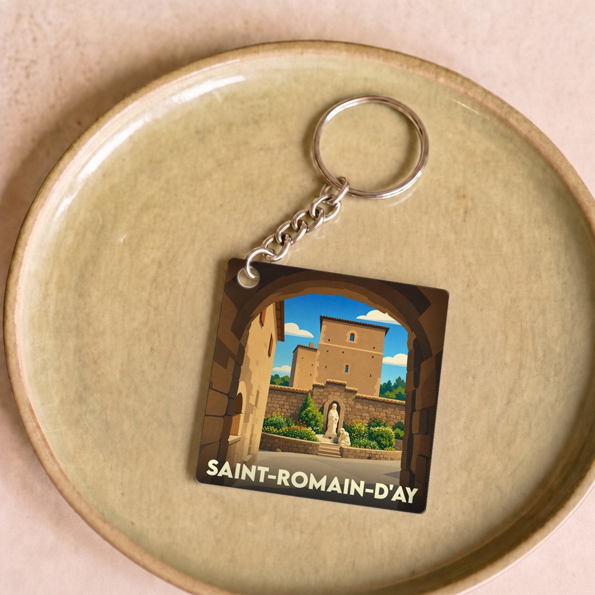Porte-clés souvenir de la ville de Saint-Romain-d'Ay avec une illustration stylisée de son patrimoine.