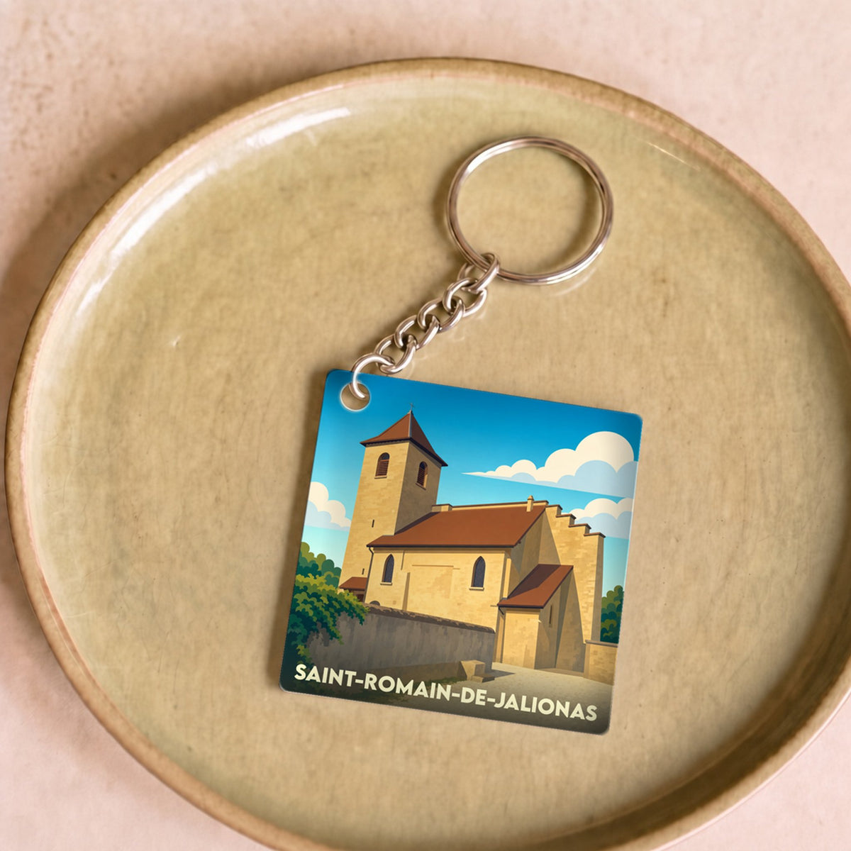 Porte-clés souvenir de la ville de Saint-Romain-de-Jalionas avec une illustration stylisée de son église.