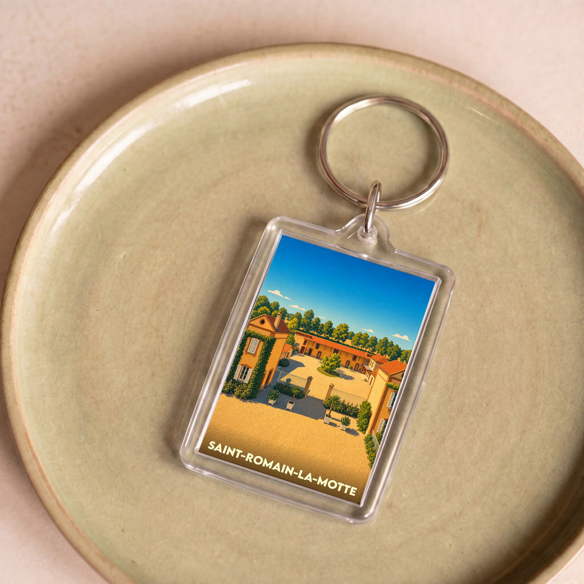Porte-clés souvenir de la ville de Saint-Romain-la-Motte avec une illustration stylisée.