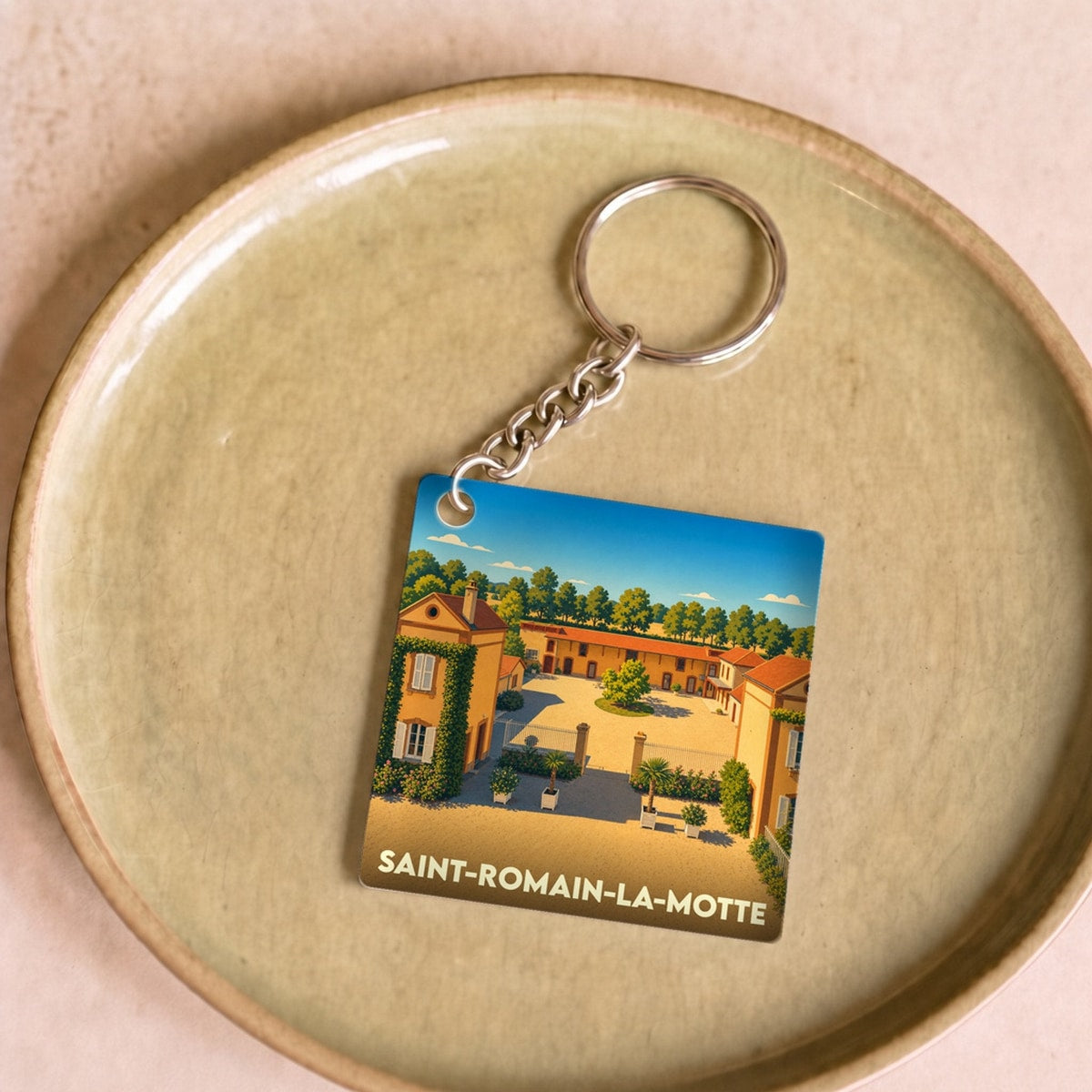 Porte-clés souvenir de la ville de Saint-Romain-la-Motte avec une illustration stylisée.