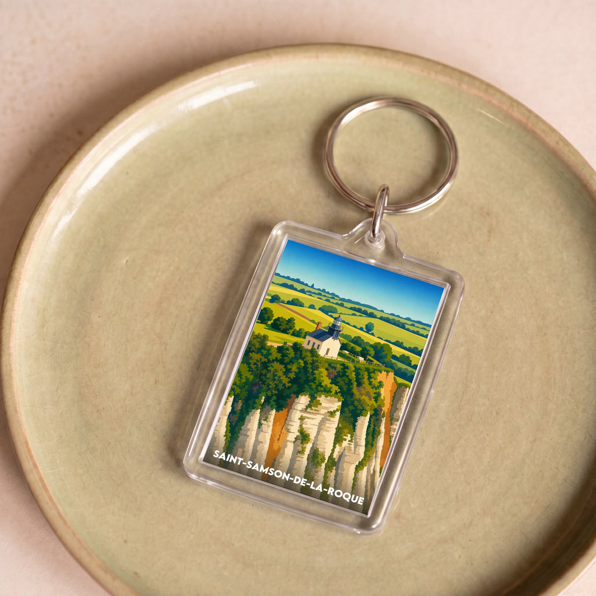 Porte-clés souvenir de la ville de Saint-Samson-de-la-Roque avec une illustration stylisée de son paysage.
