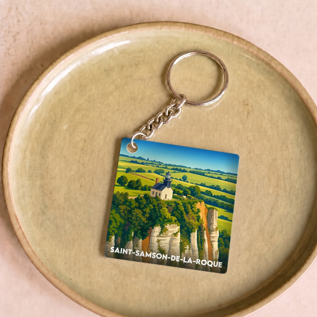 Porte-clés souvenir de la ville de Saint-Samson-de-la-Roque avec une illustration stylisée de son paysage.
