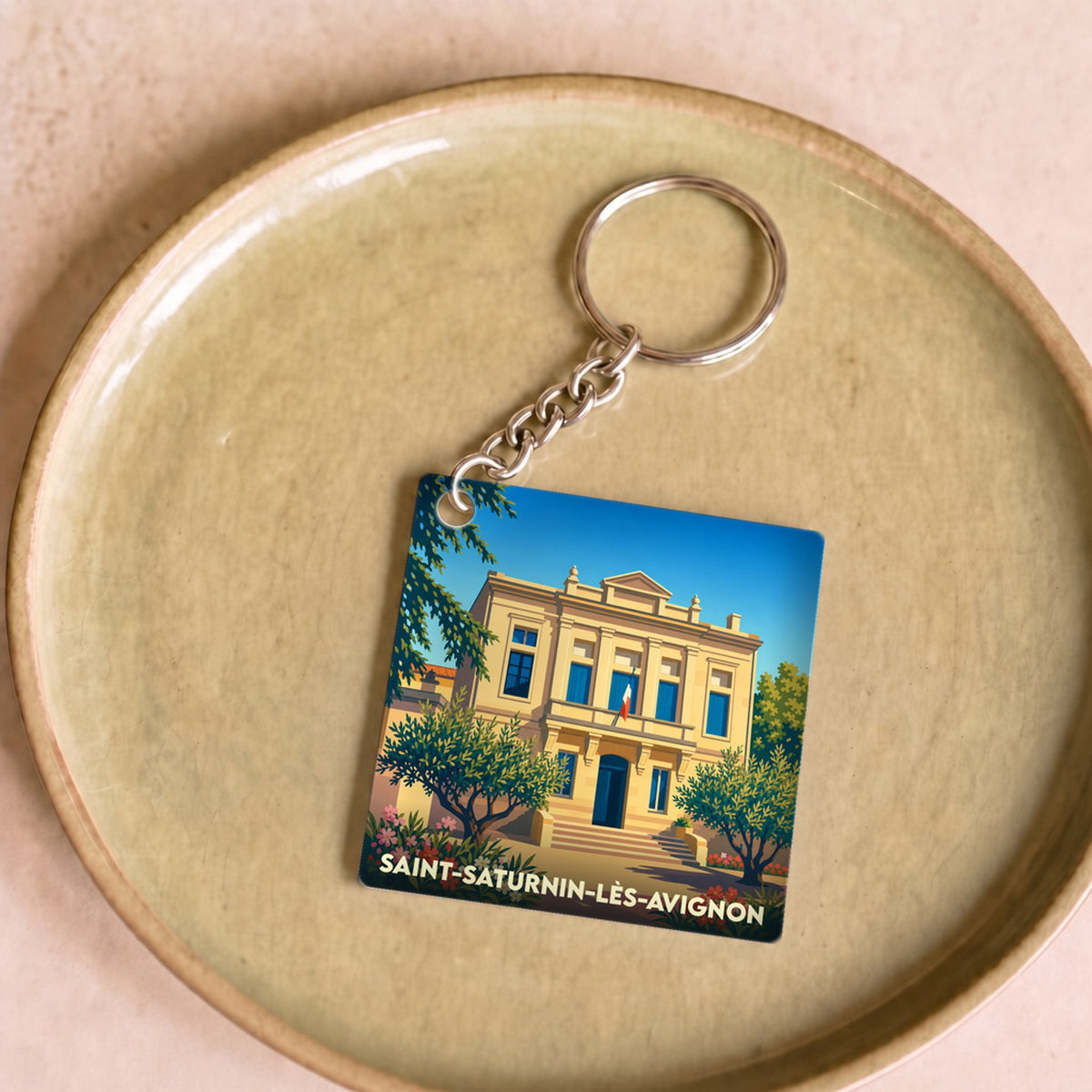 Porte-clés souvenir de la ville de Saint-Saturnin-lès-Avignon avec une illustration stylisée de sa mairie.