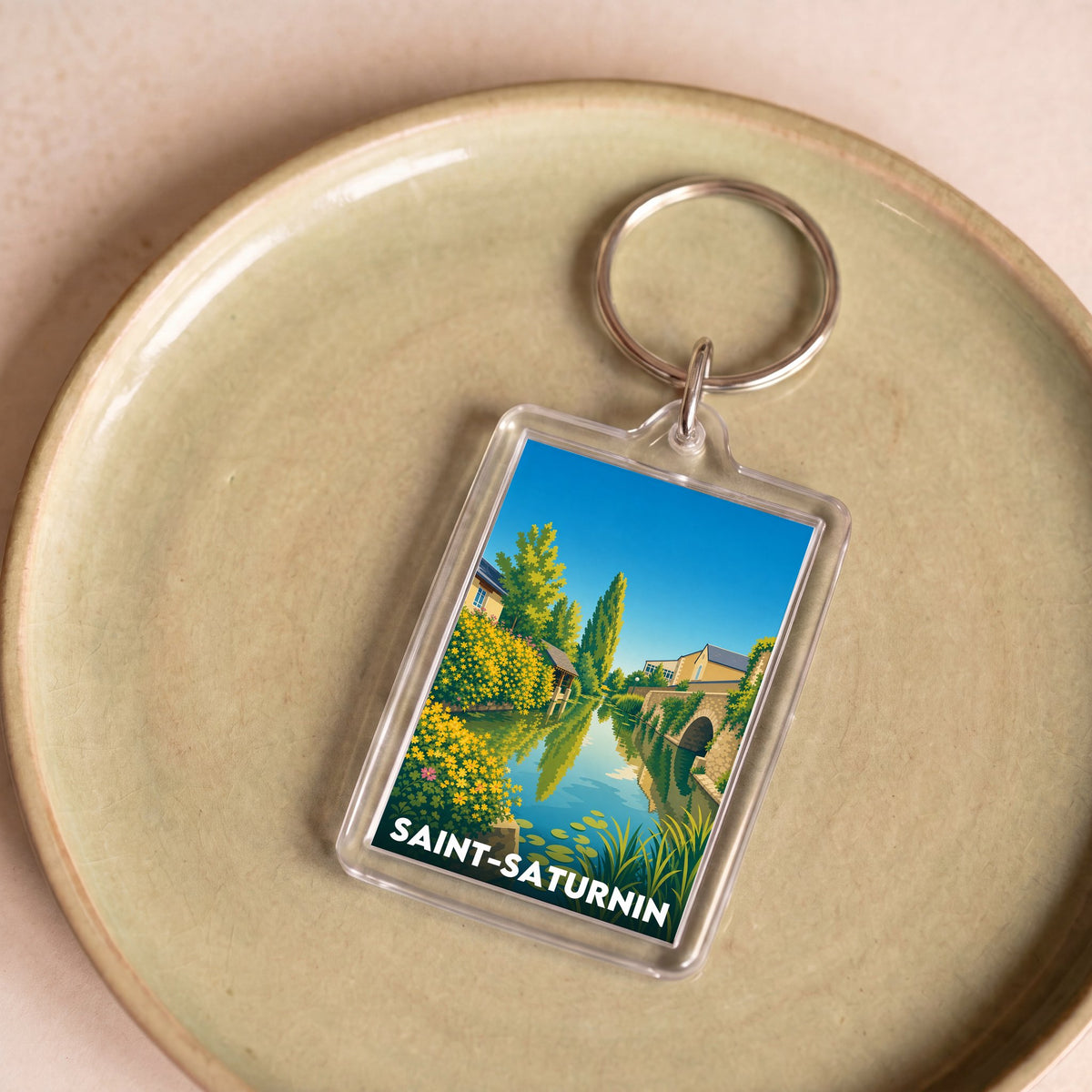 Porte-clés souvenir de la ville de Saint-Saturnin avec une illustration stylisée.