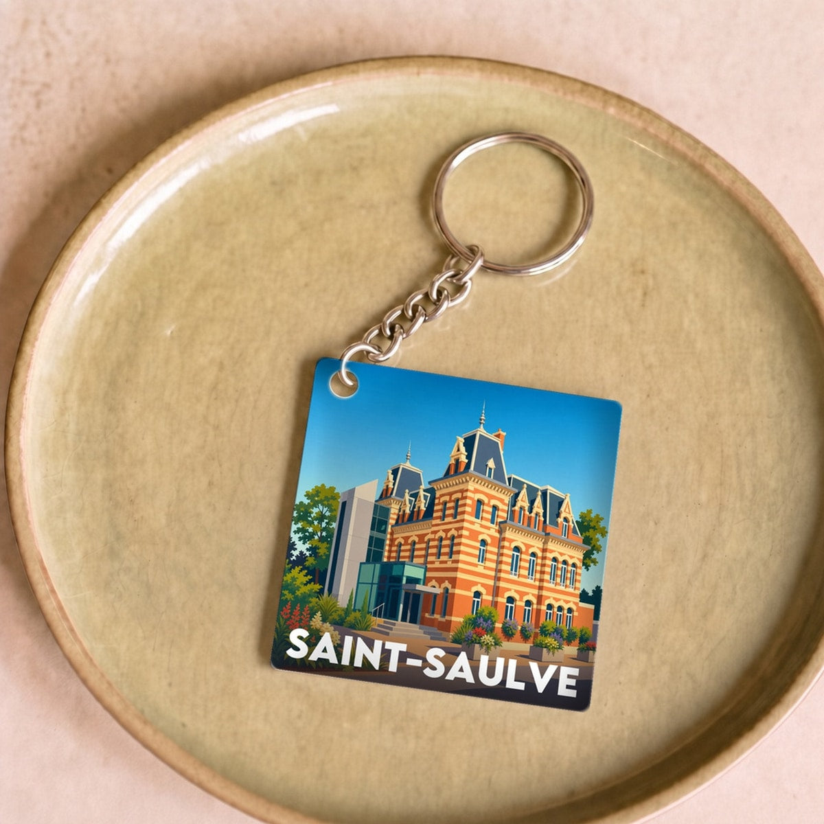 Porte-clés souvenir de la ville de Saint-Saulve avec une illustration architecturale stylisée.