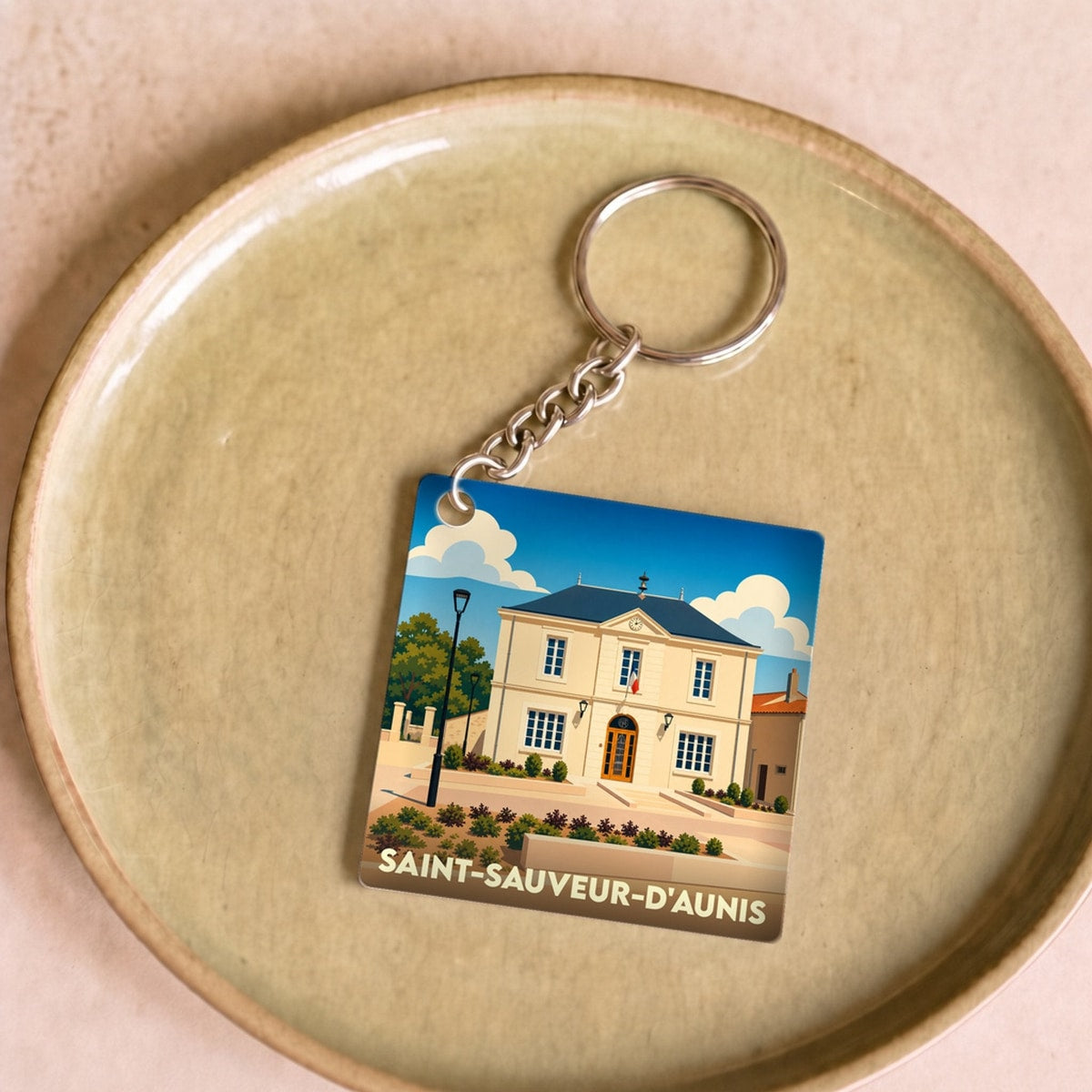 Porte-clés souvenir de la ville de Saint-Sauveur-d'Aunis avec une illustration stylisée de sa mairie.