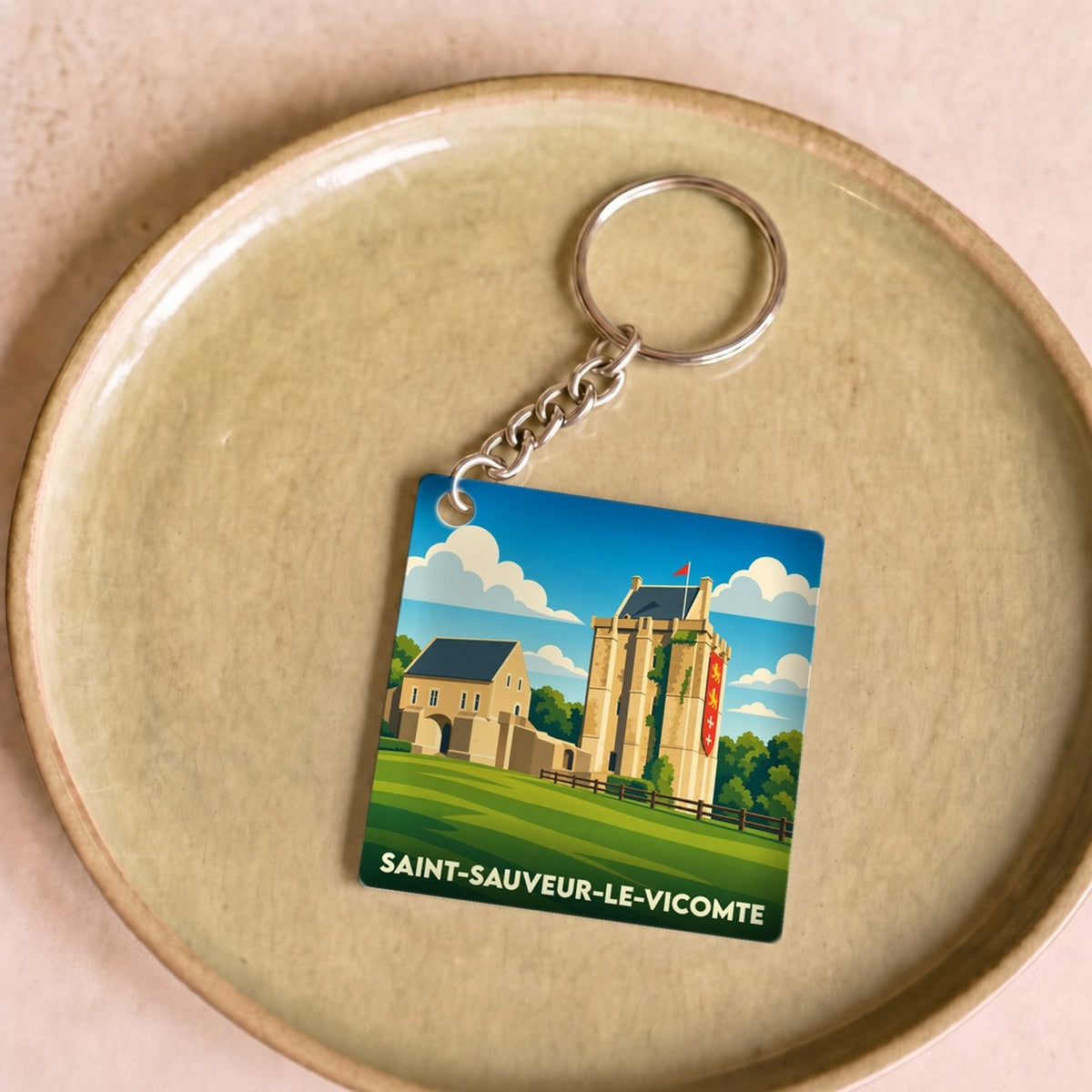 Porte-clés souvenir de la ville de Saint-Sauveur-le-Vicomte avec une illustration stylisée de son château.