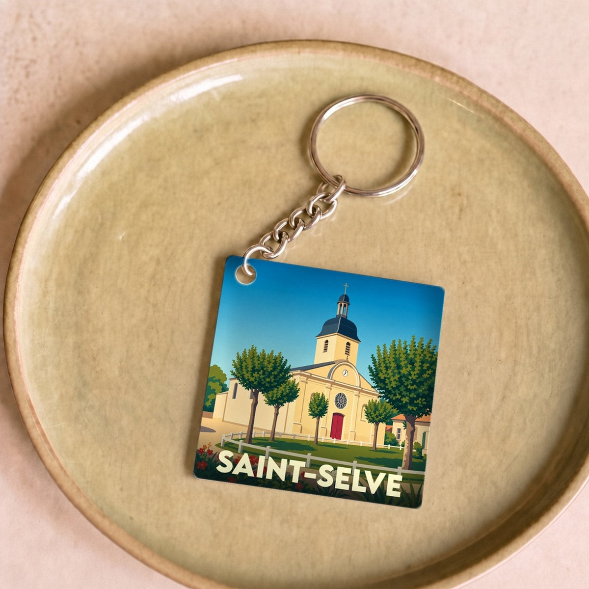 Porte-clés souvenir de la ville de Saint-Selve avec une illustration stylisée de son église.