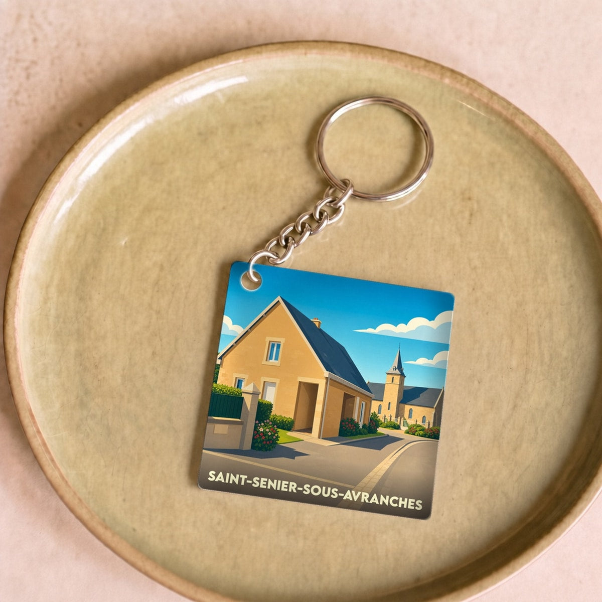 Porte-clés souvenir de la ville de Saint-Senier-sous-Avranches avec une illustration stylisée.