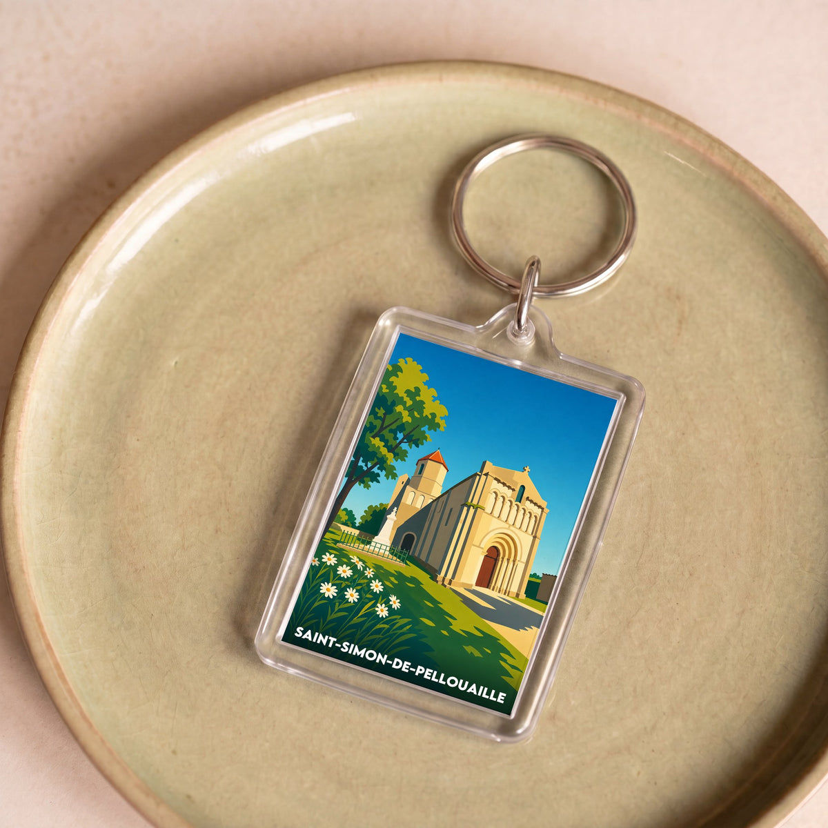 Porte-clés souvenir de la ville de Saint-Simon-de-Pellouaille avec une illustration stylisée.
