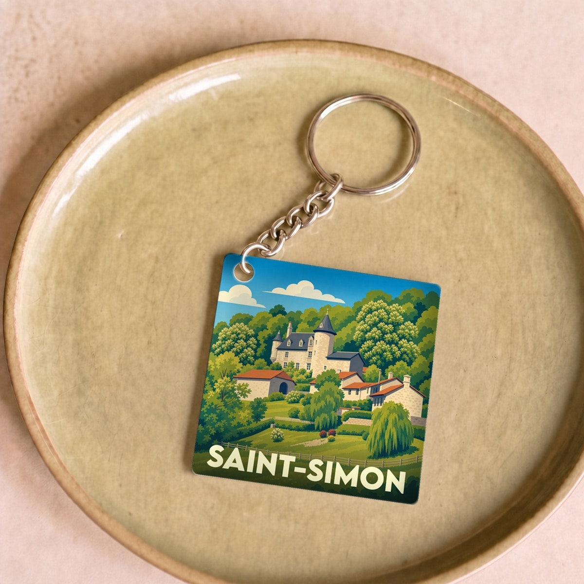 Porte-clés souvenir de la ville de Saint-Simon avec une illustration stylisée d'un paysage champêtre.