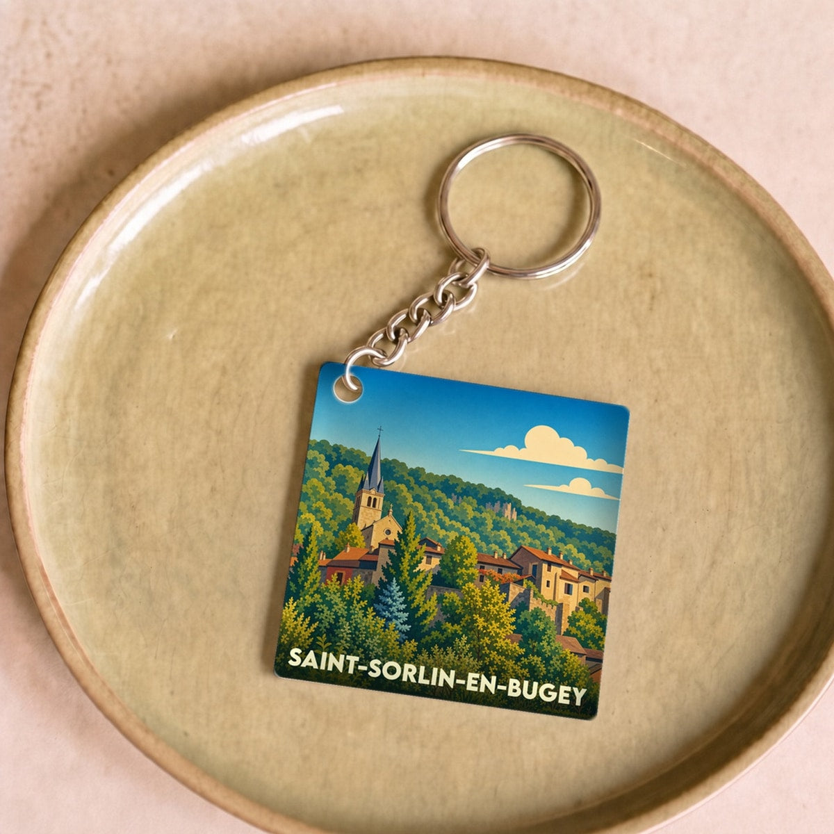 Porte-clés souvenir de la ville de Saint-Sorlin-en-Bugey avec une illustration stylisée du village.
